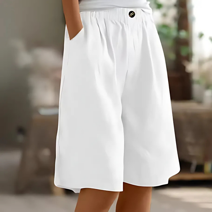White Maisie women's elastic waist Bermuda shorts with pockets and a single button closure, perfect for relaxed sunny-day styling.