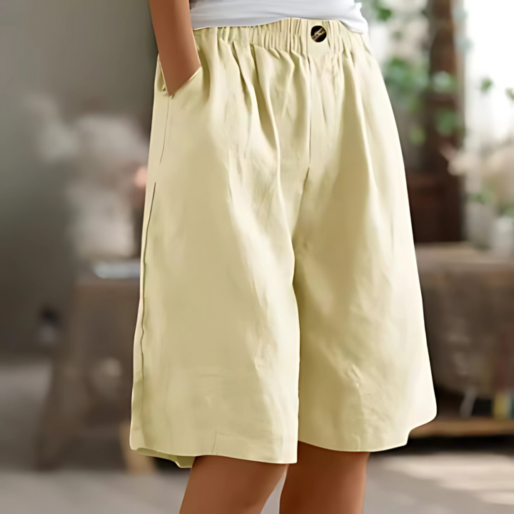 Maisie women's light yellow elastic waist Bermuda shorts with pockets and a single button detail.
