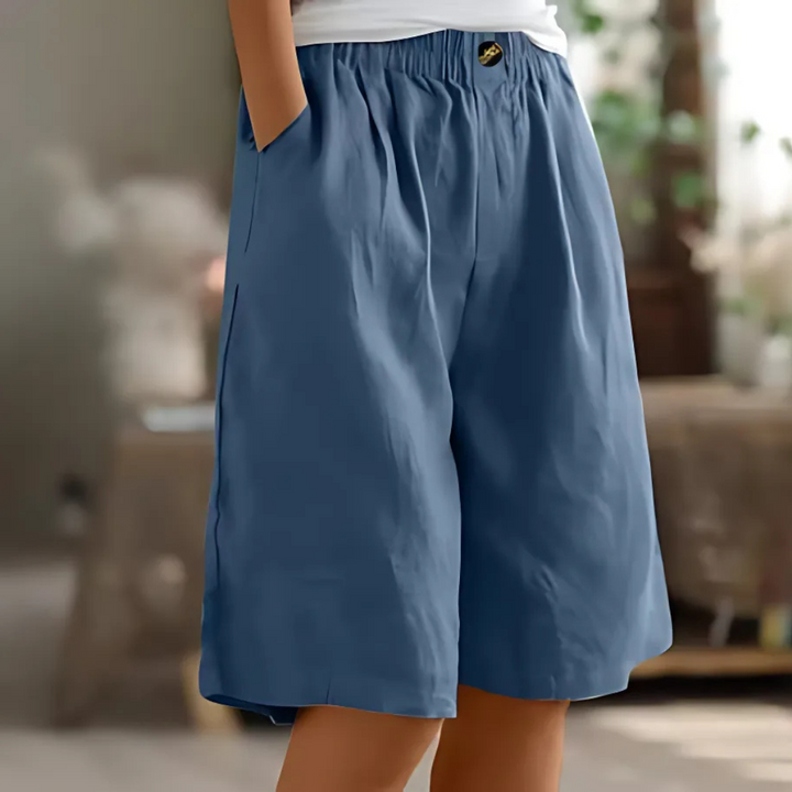 Maisie women's blue elastic waist Bermuda shorts with pockets and a single button closure, perfect for relaxed sunny days.