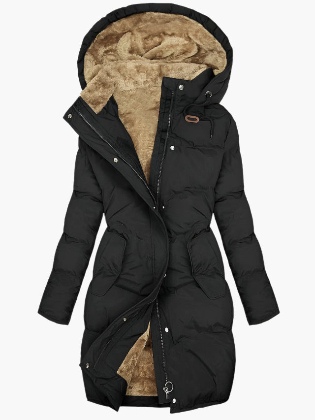 Black longline puffer coat with a plush tan faux-fur lined hood, full-length zip, and feminine shaped waist.