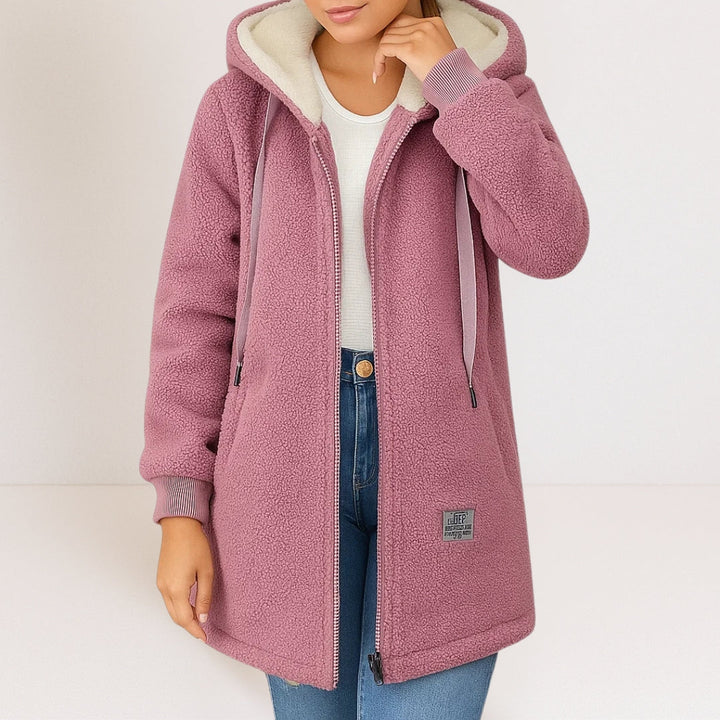 Mauve longline sherpa fleece jacket with a cream-lined hood, full-length zip, and ribbed cuffs.