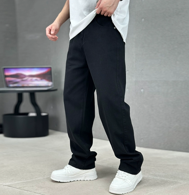 Men wearing black straight-leg denim jeans with a relaxed fit, paired with a white t-shirt and white sneakers.