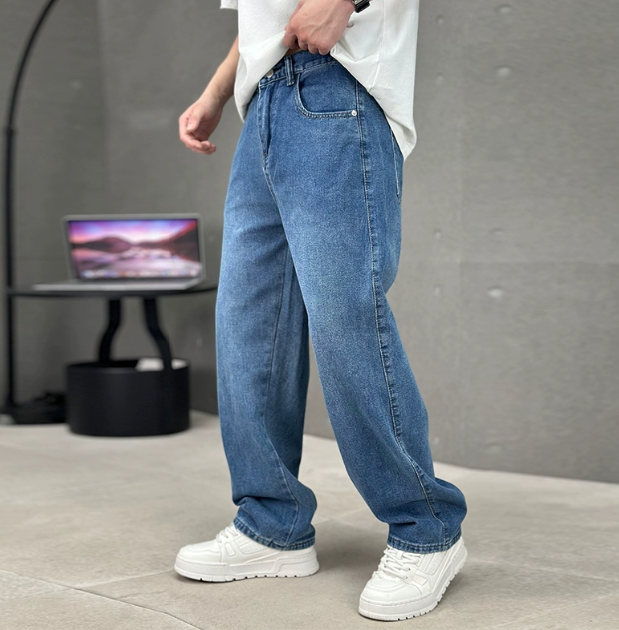 Men wearing relaxed-fit blue denim straight-leg jeans with a classic five-pocket design and white sneakers.