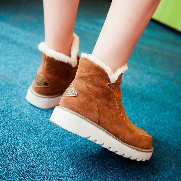 Tan suede-look ankle boots with plush faux fur trim, moccasin stitching, and a grippy white ribbed sole for winter comfort.