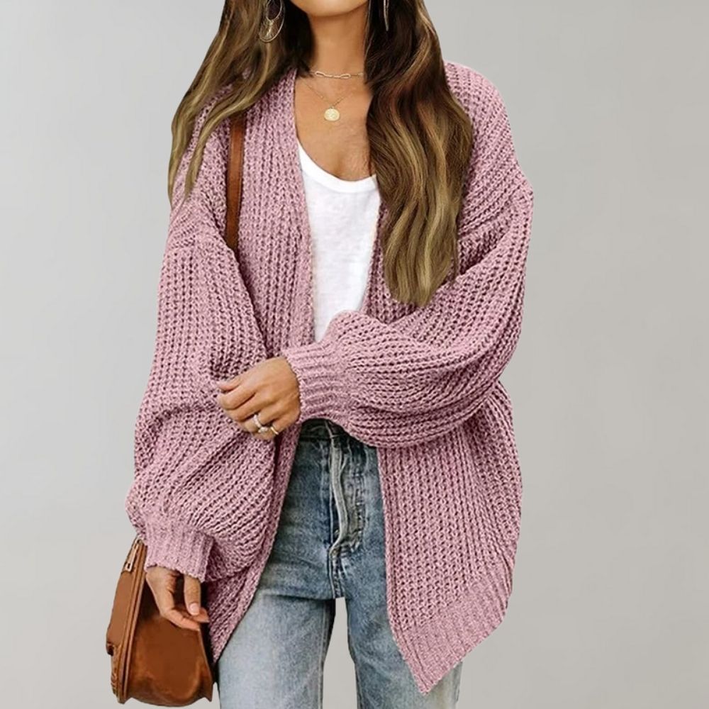 Dusty pink chunky knit oversized cardigan with an open front and balloon sleeves worn over a white tee and jeans.