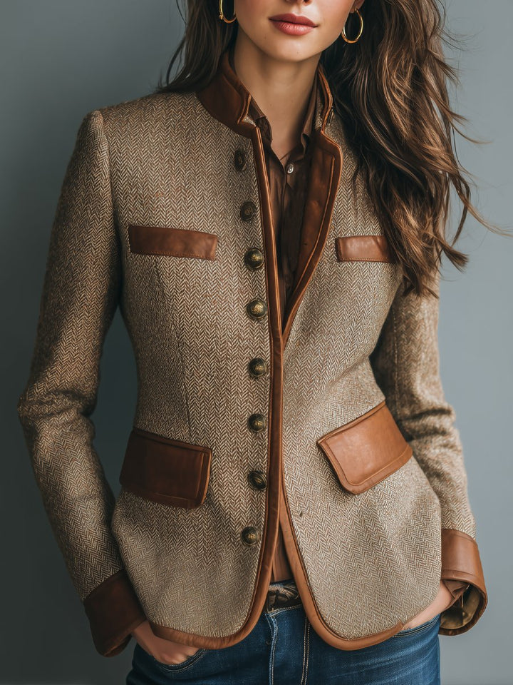 Tailored herringbone tweed blazer with brown leather-look trim, band collar, and antique brass buttons.