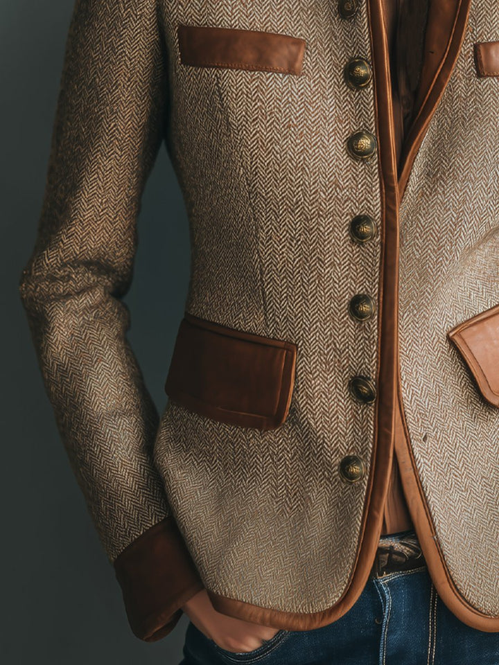 Tailored herringbone tweed blazer with brown leather-look trim, antique brass buttons, and patch pockets.