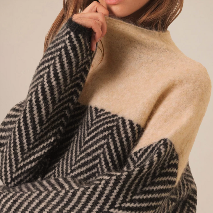 Oversized high-neck jumper in a soft, two-tone black and cream herringbone knit pattern.