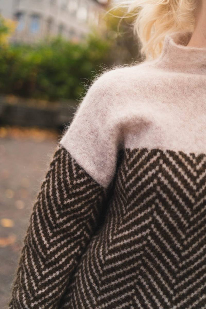 Oversized high-neck jumper in soft blush pink and dark brown two-tone herringbone knit pattern.