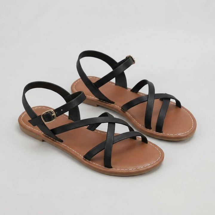 Pair of black strappy sandals on a light gray background