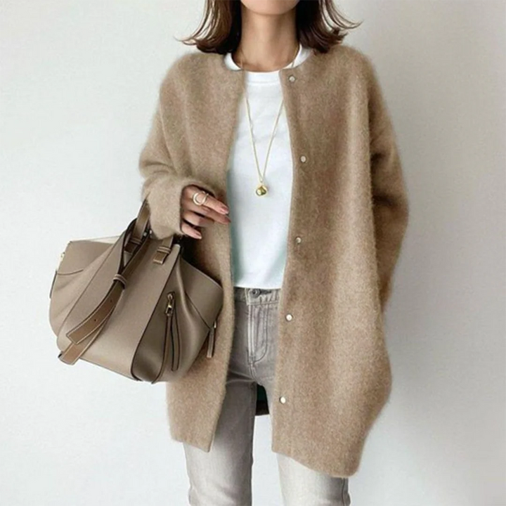 Soft beige oversized knit cardigan with a round neckline and button-up front, styled for an effortless, cozy layered look.