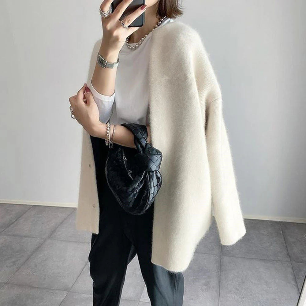Cream oversized knit cardigan with a relaxed, drapey fit and minimalist button-up front for effortless layering.