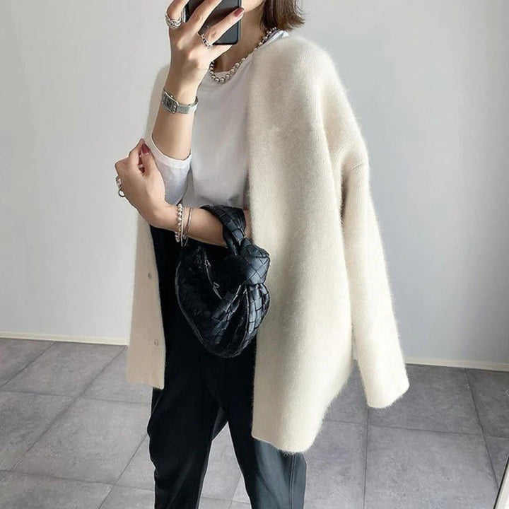 Cream oversized knit cardigan with a relaxed, drapey fit and minimalist button-up front for effortless layering.
