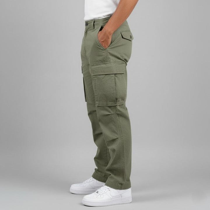 Men wearing olive green relaxed-fit cotton cargo trousers with side pockets and white sneakers.