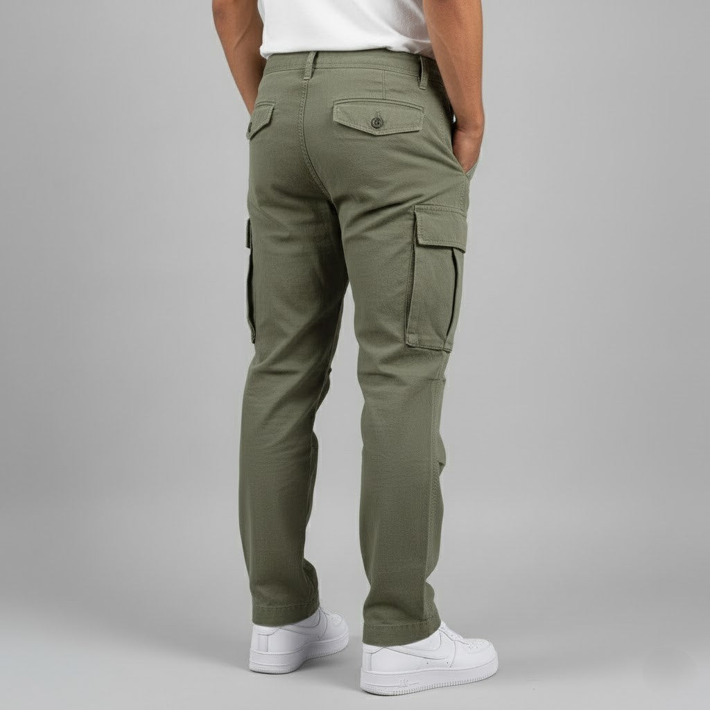 Olive green relaxed-fit men's cargo trousers with side pockets and buttoned back pockets, styled with white sneakers.