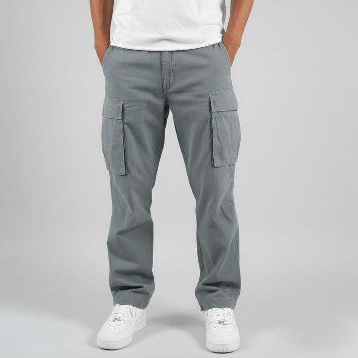 Men wearing grey relaxed-fit cotton cargo trousers with side pockets and white sneakers.