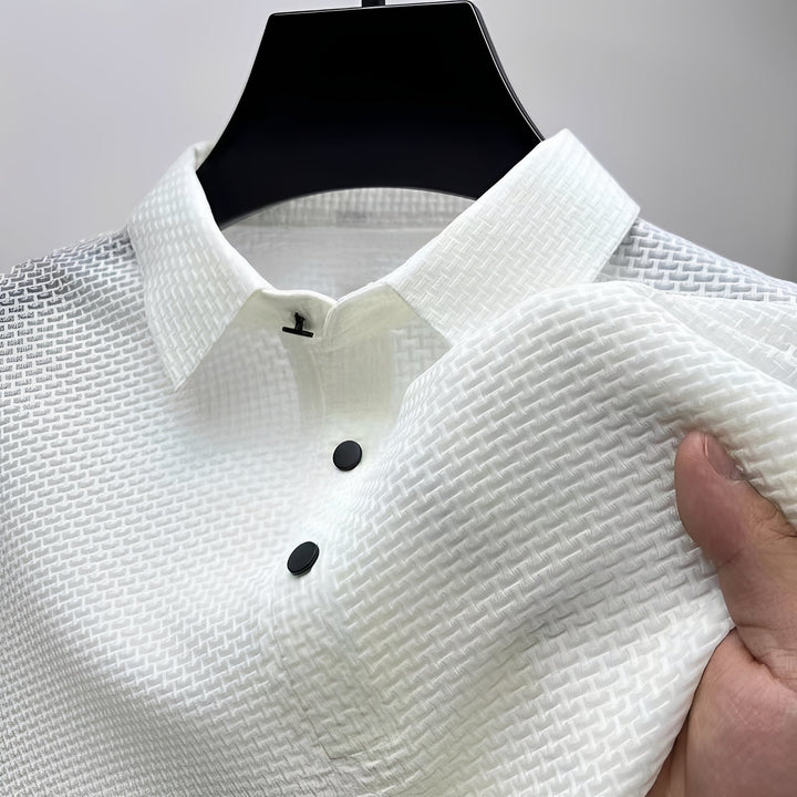 White short-sleeve polo shirt featuring a textured waffle-weave fabric, a spread collar, and two black buttons.