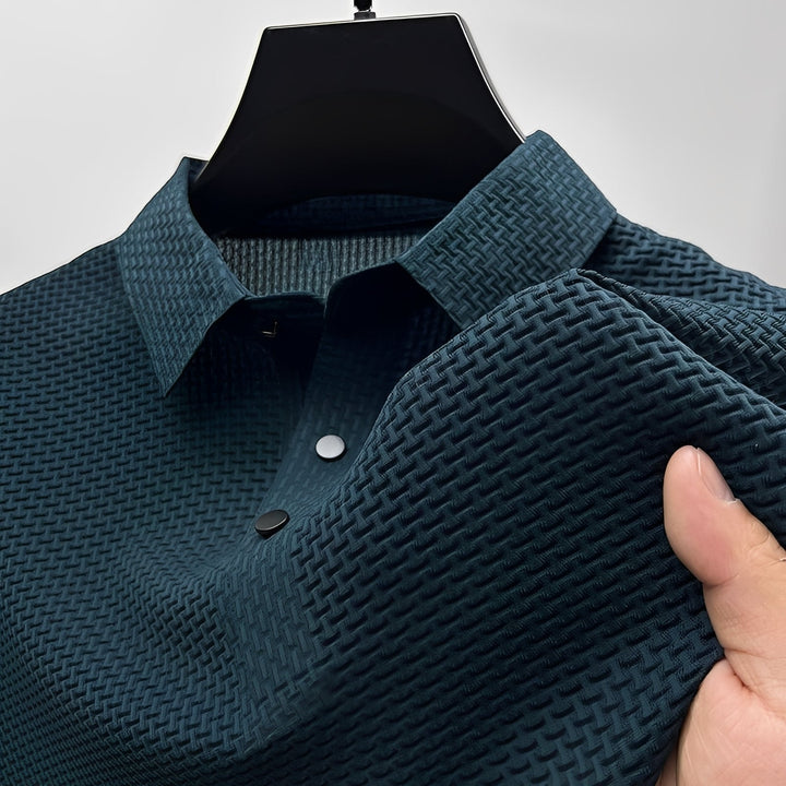 Dark teal short-sleeve polo shirt with a textured waffle-weave pattern, spread collar, and two-button placket.