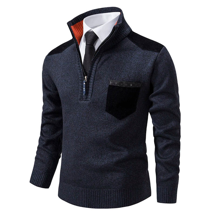 Navy blue quarter-zip knit jumper with contrast shoulder patches, chest pocket, and orange funnel neck detail.