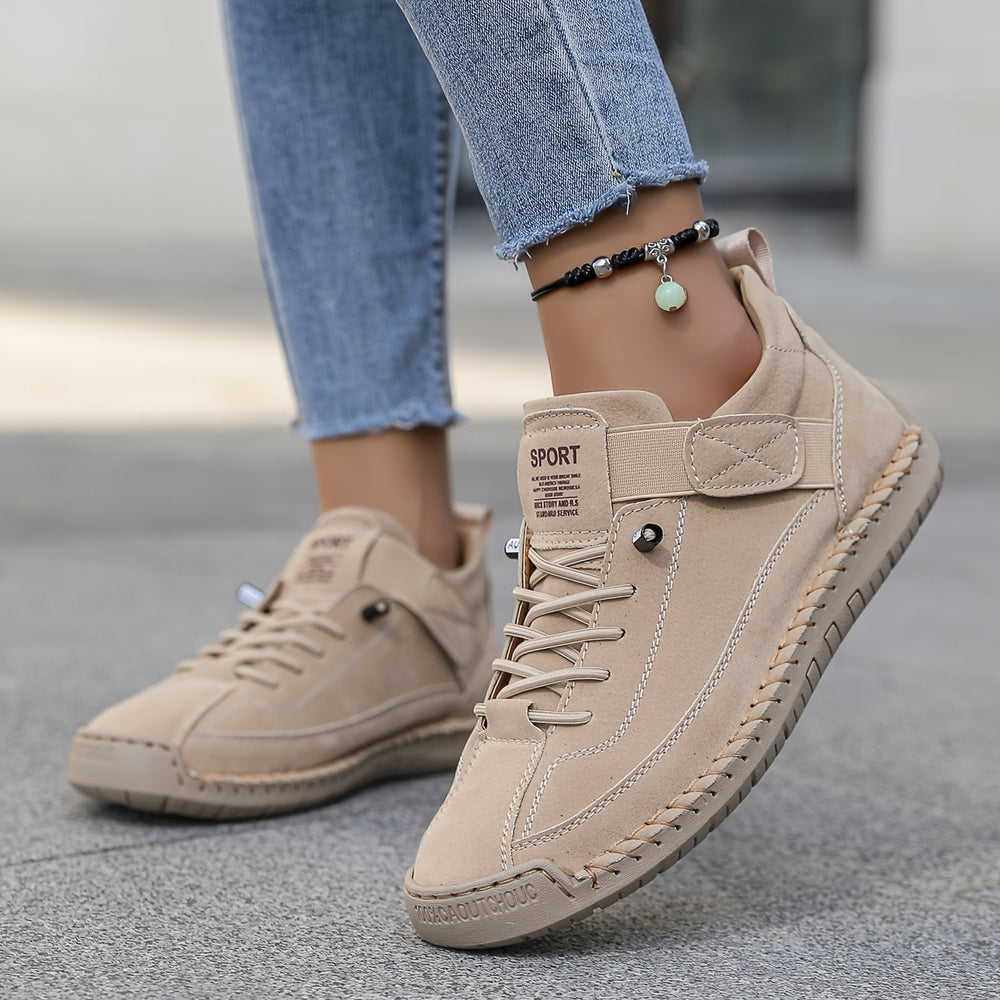 Beige Nora trainers with contrast stitching, lace-up front, and a practical hook-and-loop strap for a secure, stylish fit.