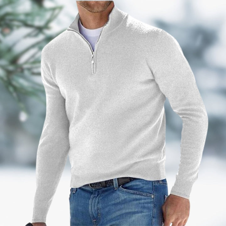 Light grey slim-fit men's quarter-zip knit sweater with a stand collar and ribbed cuffs worn over a white tee.