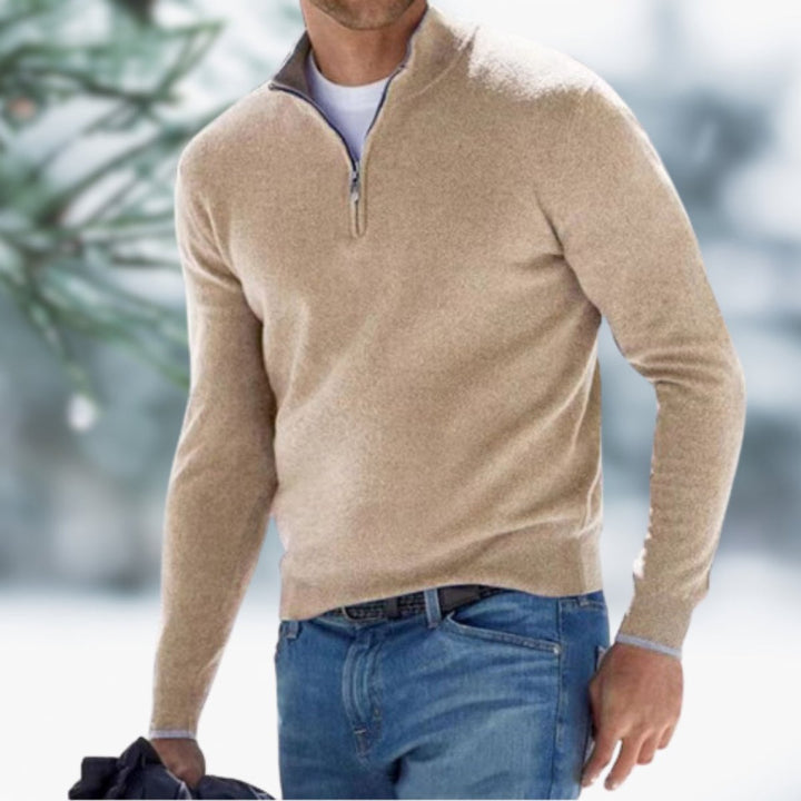 Men’s slim-fit tan knit quarter-zip sweater with a stand collar and ribbed cuffs worn over a white tee and blue jeans.