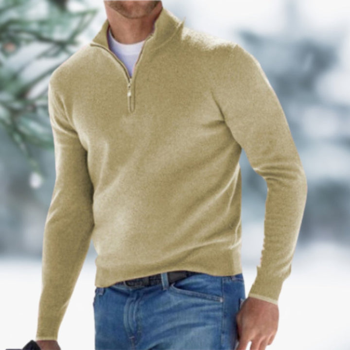 Tan slim-fit men's quarter-zip knit sweater with a stand collar and ribbed cuffs worn over a white tee and blue jeans.