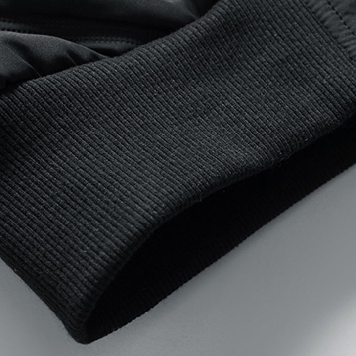 Close-up of a black quilted jacket featuring a snug, ribbed knit cuff for a tailored fit.