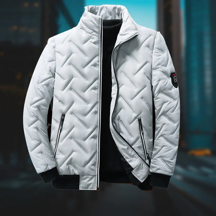 White quilted chevron padded jacket with a stand-up collar, zip pockets, and black ribbed cuffs.