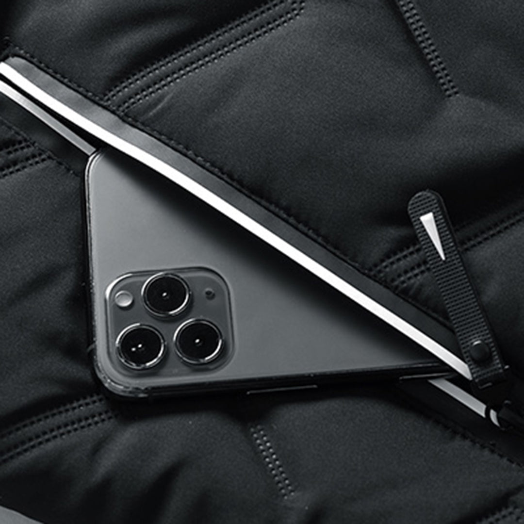 Close-up of a black quilted men's jacket featuring a secure zip pocket holding a smartphone.
