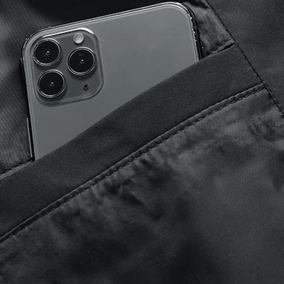Black quilted jacket featuring a secure zip pocket holding a smartphone.