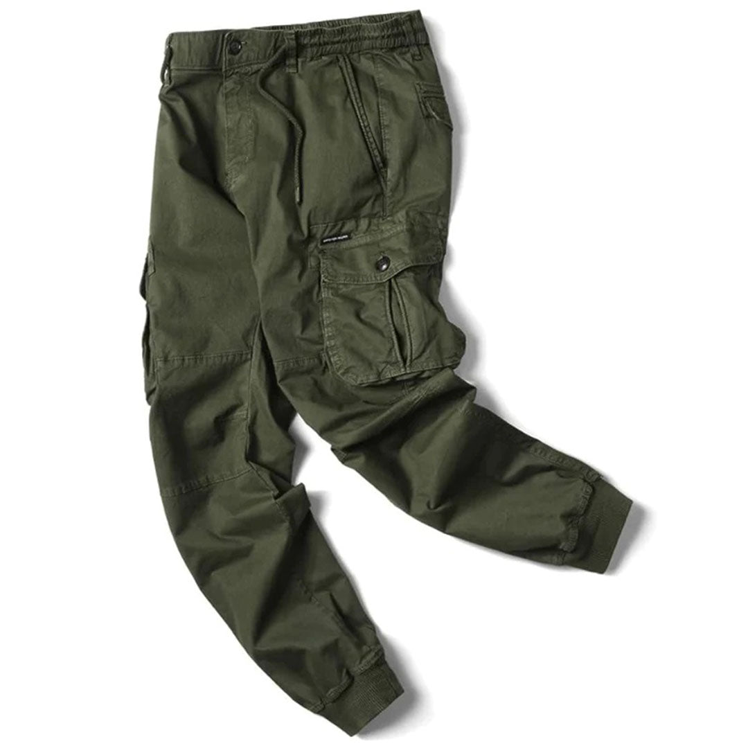 Olive green cotton utility cargo trousers with an elasticated drawstring waist, side flap pockets, and cuffed ankles.