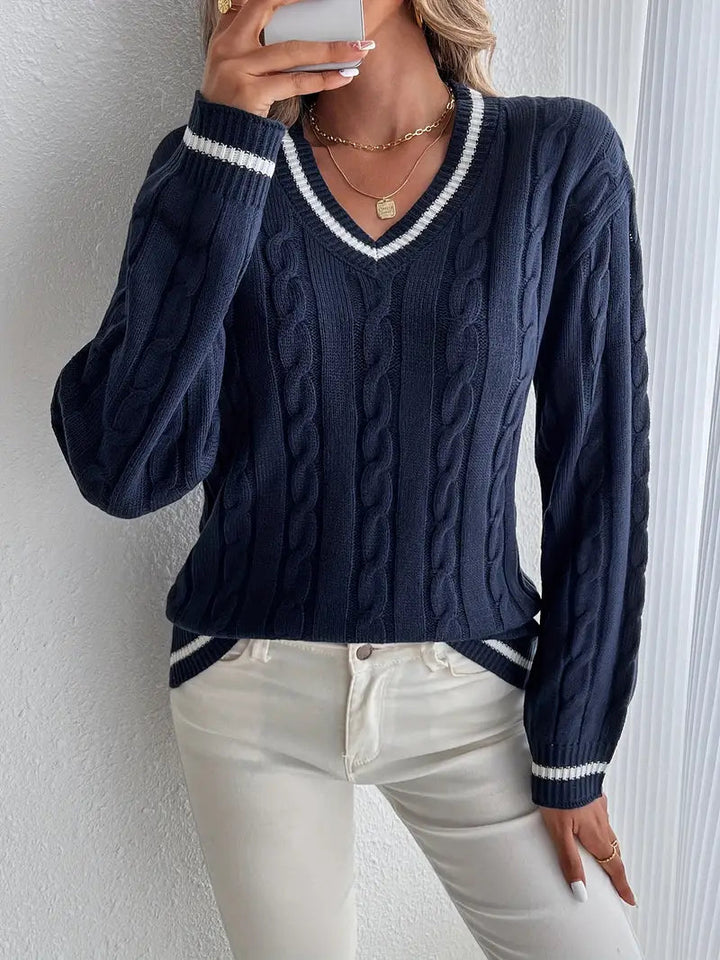 Navy blue cable knit V-neck jumper with white striped trim on collar, cuffs, and hem for a sporty, relaxed fit.