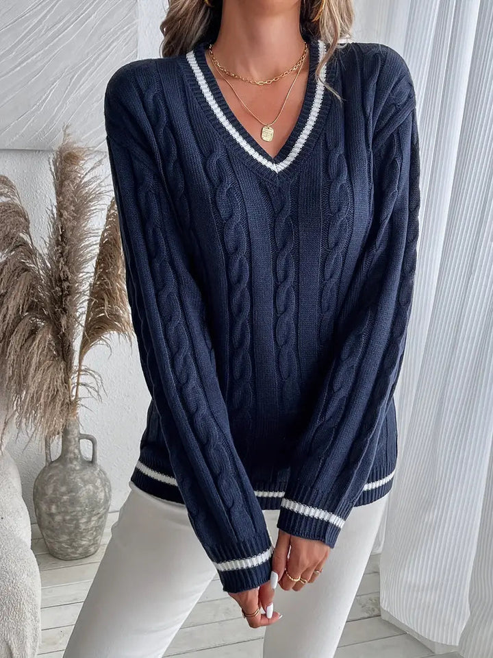 Navy cable knit V-neck jumper with white striped trim on the collar, cuffs, and hem in a relaxed, sporty-smart fit.