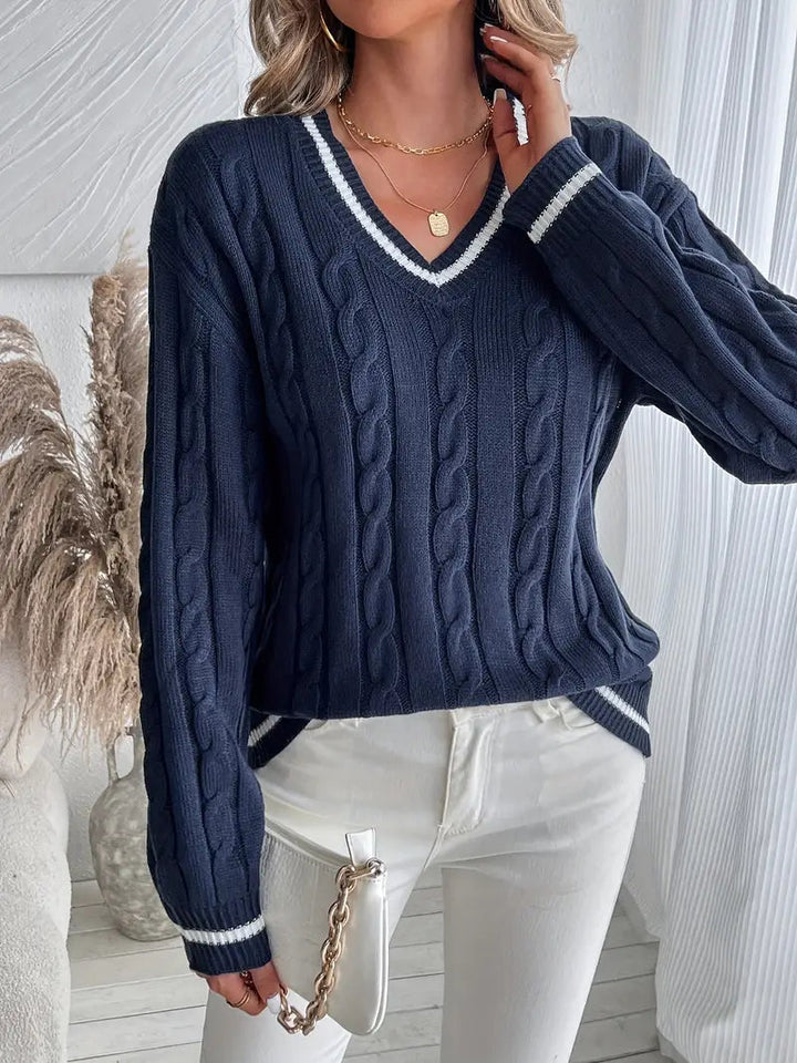Navy blue cable knit V-neck jumper with white striped trim on the collar, cuffs, and hem in a relaxed fit.