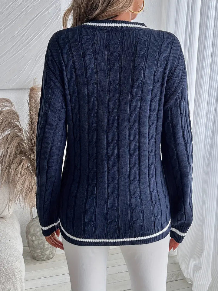 Navy cable knit V-neck jumper with white striped trim on the cuffs and hem in a relaxed, sporty-smart silhouette.