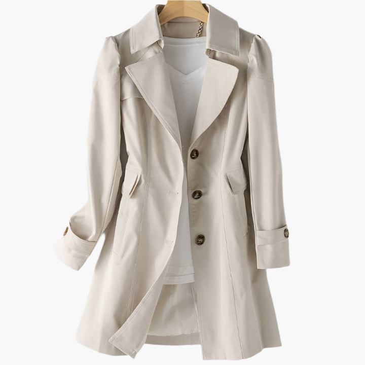 Beige tailored trench coat featuring a sharp lapel collar, statement buttons, and a flattering mid-length silhouette.