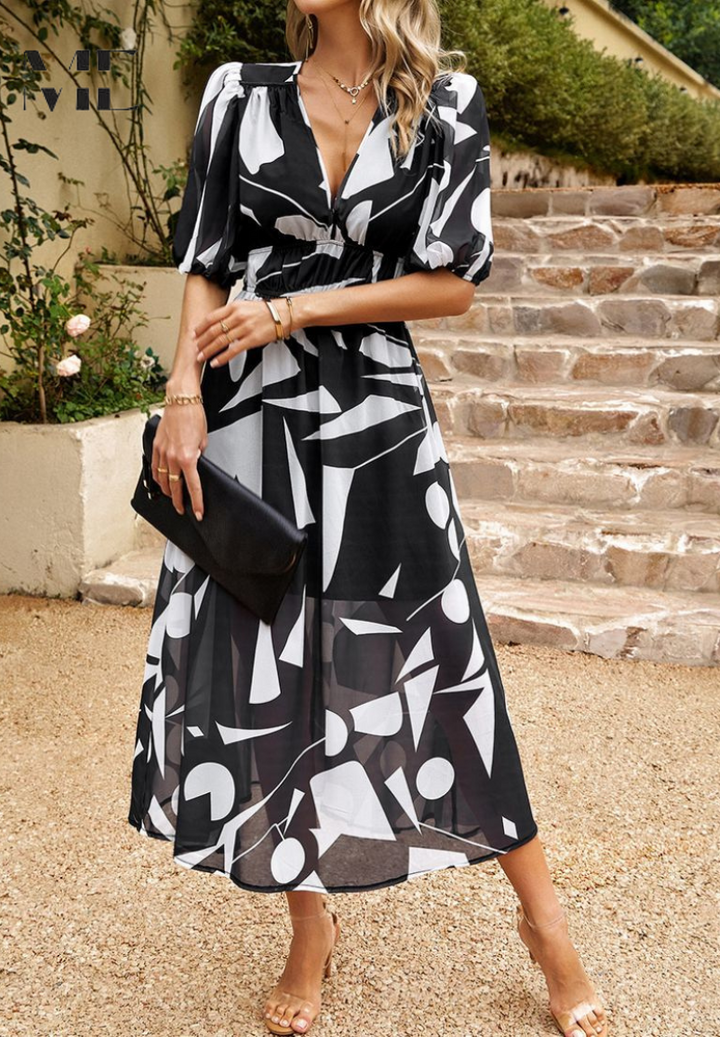 Woman wearing a black and white abstract floral midi dress with a V-neckline, puff sleeves, and a gathered waist.