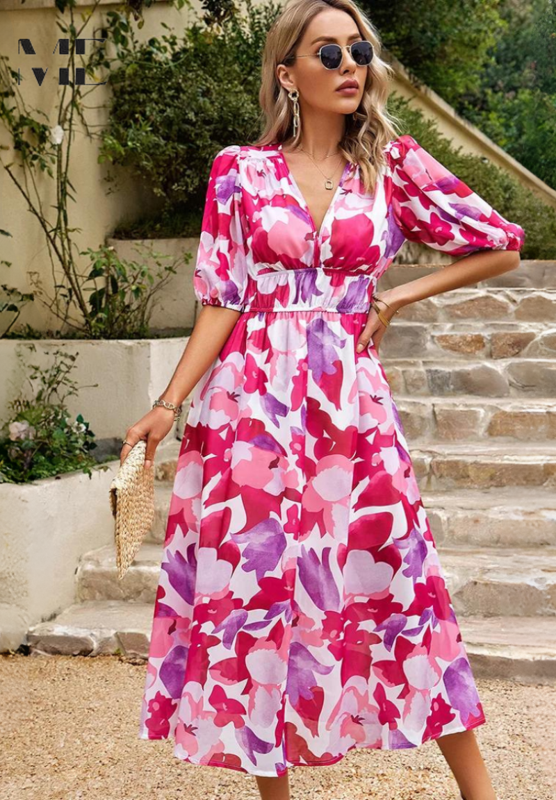 Woman wearing a pink and purple floral midi dress with a V-neckline and puff sleeves, standing on stone steps.