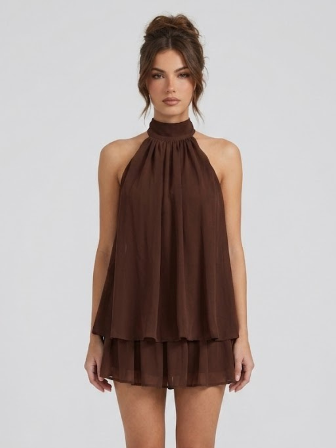 Dark brown halter neck mini dress with a tiered ruffle hem and lightweight, flowy fabric.
