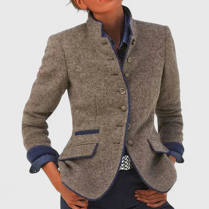 Taupe wool-blend blazer with a stand collar, button-front closure, and navy blue contrast trim on pockets and cuffs.