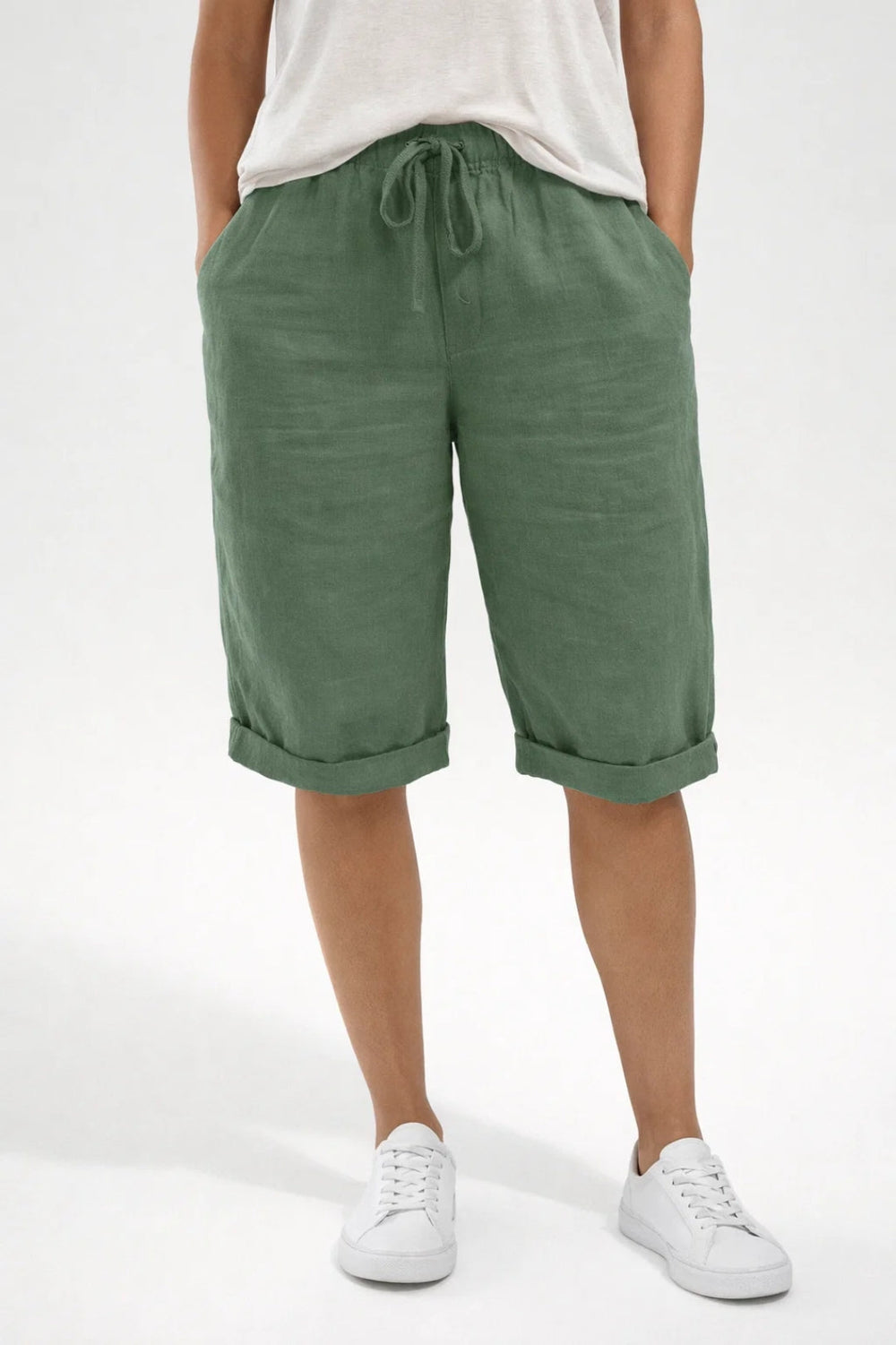 Sage green linen shorts with a drawstring elastic waist, side pockets, and relaxed turn-up hems.