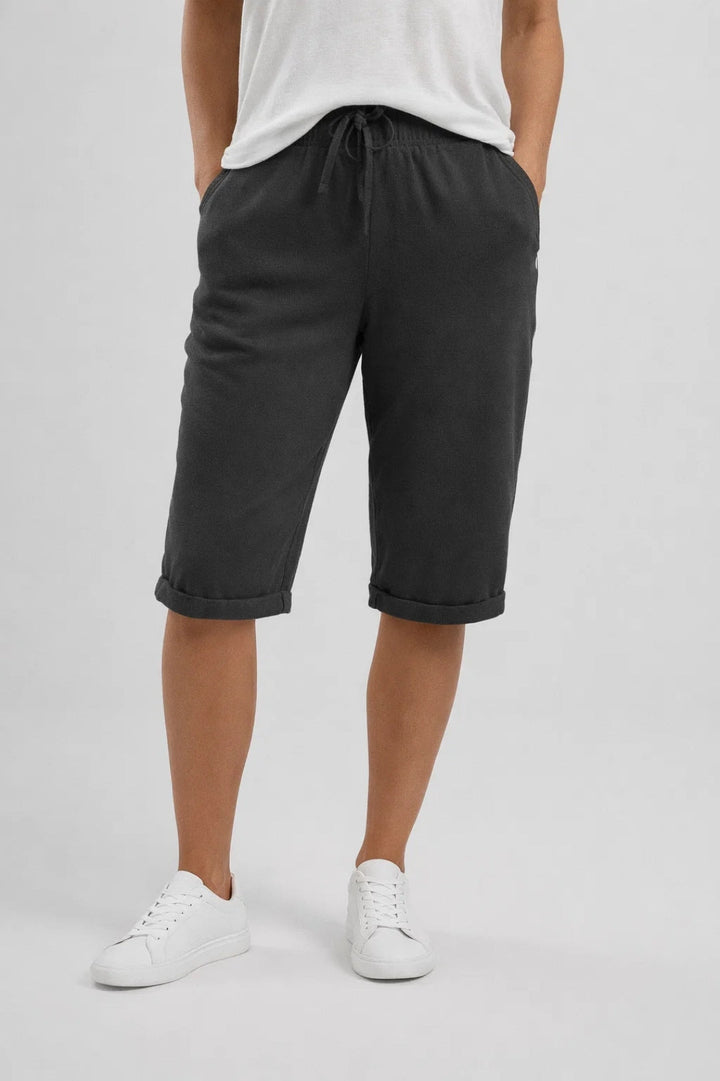 Charcoal grey linen shorts with a drawstring elastic waist, knee-length wide-leg cut, and rolled-up hems.