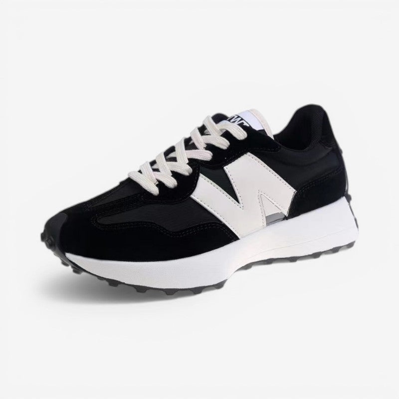 Poppy retro trainers in black and white with a mixed-panel upper, lace-up front, and a chunky cushioned sole.