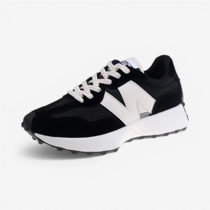 Poppy retro trainers in black and white with a mixed-panel upper, lace-up front, and a chunky cushioned sole.