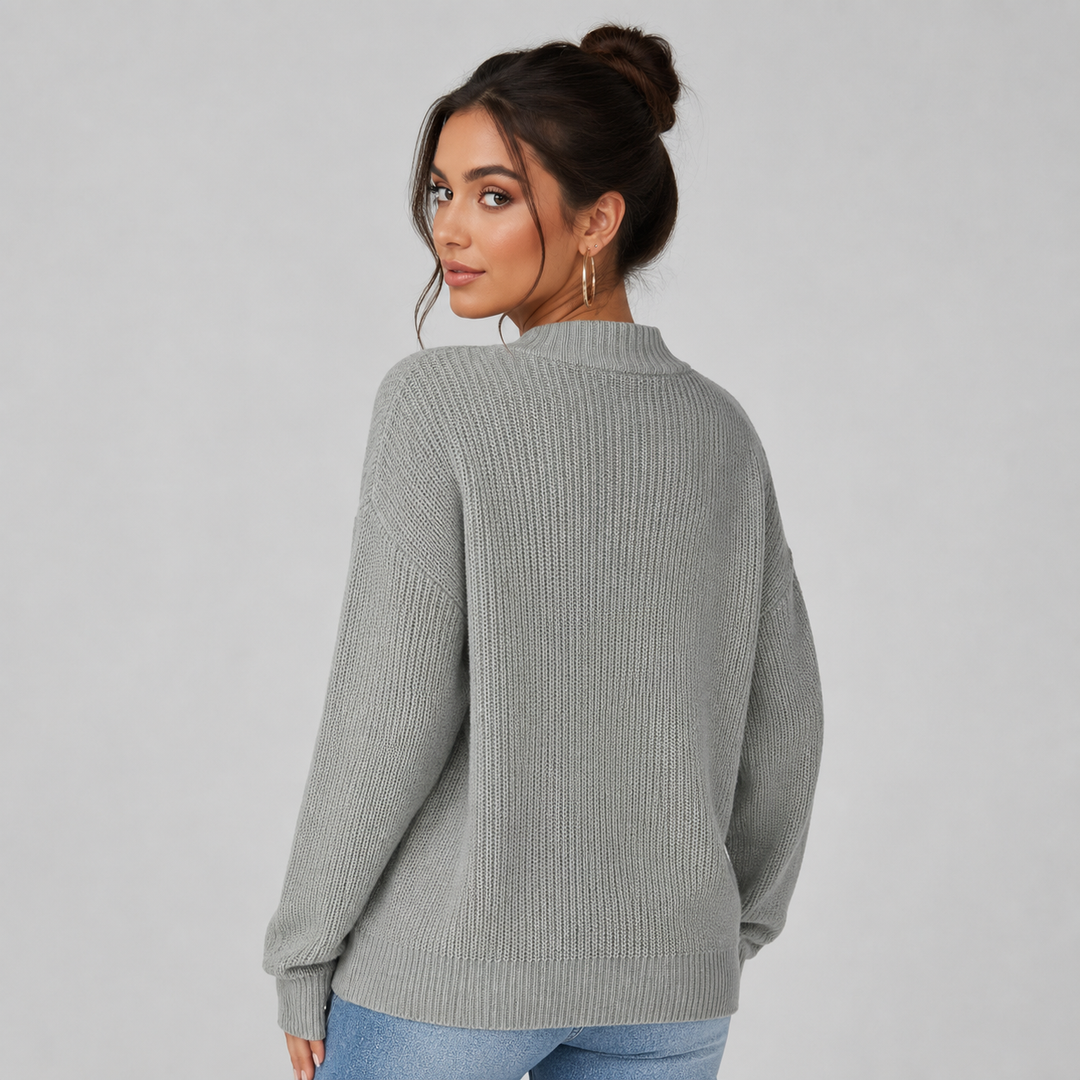 Woman wearing a cosy grey ribbed knit cardigan with a relaxed, oversized fit and drop shoulders.