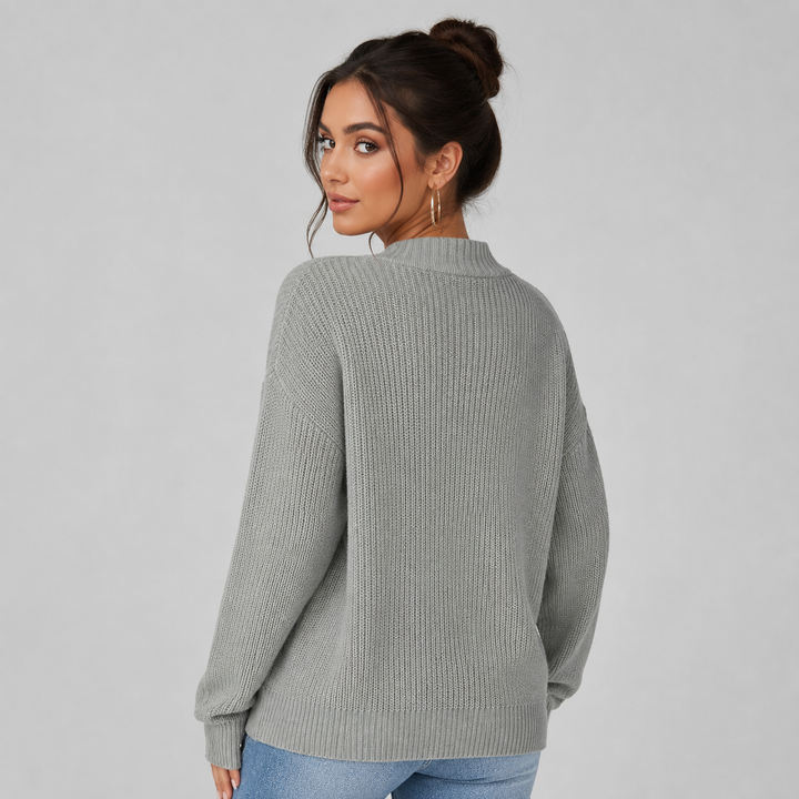 Woman wearing a cosy grey ribbed knit cardigan with a relaxed, oversized fit and drop shoulders.