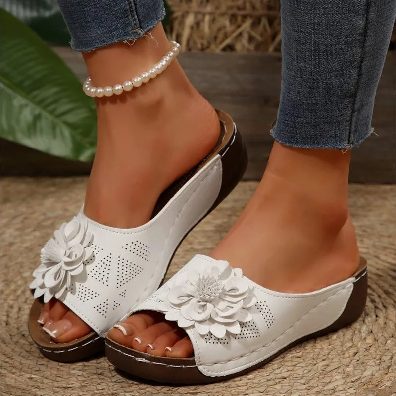 White Poppy slip-on wedge sandals with delicate floral upper detail and cushioned footbed.