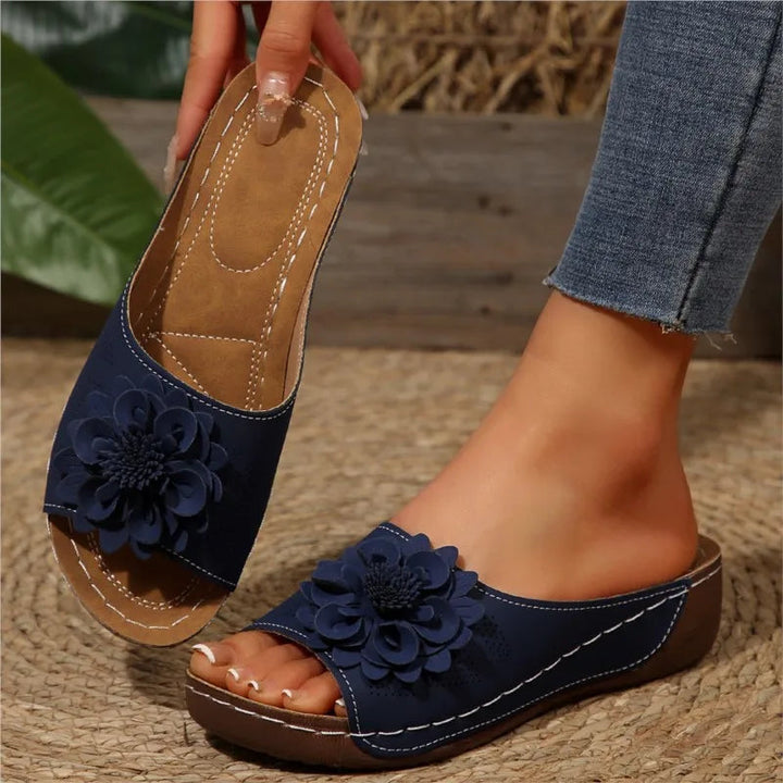 Navy Poppy slip-on wedge sandals with delicate floral upper detail and cushioned footbed.