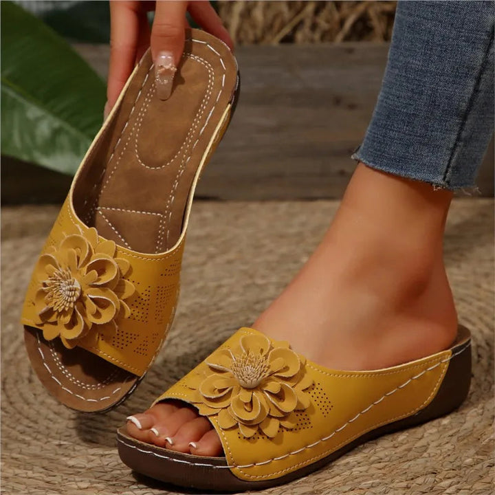 Poppy women's slip-on wedge sandals in mustard yellow with a delicate floral upper detail and cushioned footbed.